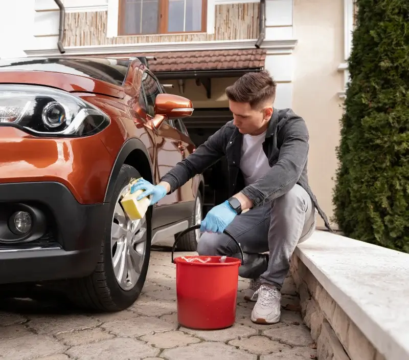 Lavage auto à domicile Frenelles-en-Vexin : professionnel intervenant sur un véhicule